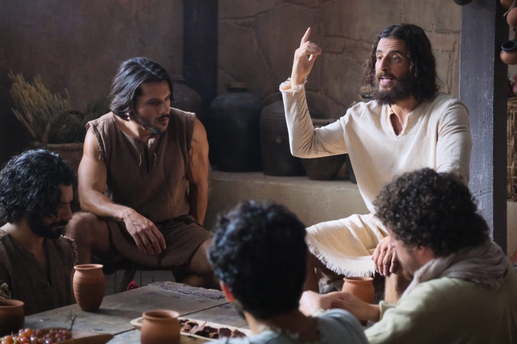 Jesus as portrayed in the TV series 'The Chosen' is sitting talking to his dicsiples.